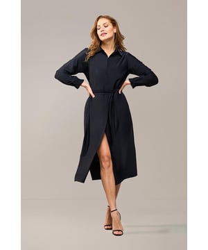 Deze doorknoopjurk uit de nieuwste Mart Visser collectie is een echte must-have voor iedere garderobe. Het tijdloze en elegante ontwerp maakt deze jurk geschikt voor dagelijks gebruik. Gemaakt van zachte travelstof, biedt de zwarte jurk zowel comfort als bewegingsvrijheid. De bijpassende strikceintuur zorgt ervoor dat je eenvoudig de perfecte pasvorm kunt creëren. De jurk heeft praktische steekzakken, een klassieke reverskraag en elastische details bij de mouwen, wat zorgt voor een subtiel ruffle-effect. De rechte pasvorm van de jurk valt elegant tot op de kuit. Bovendien kun je de jurk open dragen als een lange blouse, gecombineerd met een jeans en een stijlvolle top of basic singlet. Op zoek naar een andere kleur? Kijk dan ook naar de navy versie van deze prachtige jurk! De zwarte doorknoopjurk is de perfecte toevoeging aan je garderobe en een echte investering voor de toekomst.