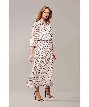 Een echte blikvanger in je garderobe! De Nikita plissérok is versierd met een prachtig abstract stippenpatroon in zachte, neutrale tinten op een offwhite achtergrond. De elegante rok heeft abstracte bruine stippen en een comfortabele, elastische tailleband voor extra draaggemak. De rok valt net boven de enkel en heeft een wijd uitlopende snit. Gemaakt van 100% polyester met een voering van 100% viscose, biedt deze plissérok zowel stijl als comfort. De offwhite midi-rok is dit seizoen een echte eyecatcher! Combineer hem met de bijpassende blouse voor een complete jurk-look, of draag hem met een sneaker en een gebreide top voor een casual uitstraling. Of je nu voor een formele look gaat voor op kantoor of een chique, casual outfit voor een avondje uit, deze gedessineerde rok is de perfecte keuze.