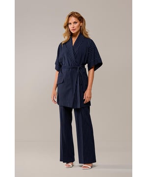 De Roseline blazer is een stijlvolle en veelzijdige toevoeging aan je garderobe. Met zijn elegante navy-witte krijtstreep straalt deze blazer tijdloze klasse uit. De overslag met een strikceintuur in de taille creëert een speels en vrouwelijk accent, terwijl subtiele schoudervullingen zorgen voor een mooi gevormd silhouet. Dit maakt de blazer perfect voor zowel zakelijke als casual gelegenheden. Je kunt de Roseline blazer solo dragen als statement-piece of combineren met bijpassende items, zoals het Chloe gilet Navy/Wit, voor een volledig gecoördineerde look. Deze blazer is eenvoudig te stylen: draag hem met een witte blouse en een nette navy broek of rok voor een elegante uitstraling. Maak je look af met hakken of stijlvolle loafers. Dankzij de klassieke krijtstreep is deze blazer een tijdloze en veelzijdige keuze voor elke gelegenheid.