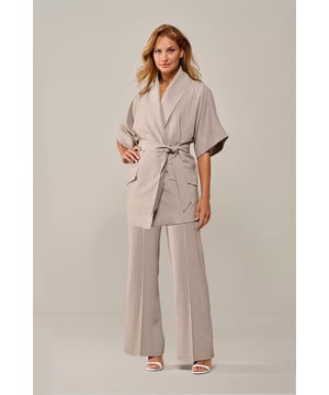 De Roseline blazer is een stijlvolle en veelzijdige toevoeging aan je garderobe. Met zijn elegante zand-witte krijtstreep straalt deze blazer verfijning en klasse uit. De overslag met strikceintuur in de taille benadrukt het vrouwelijke silhouet, terwijl subtiele schoudervullingen zorgen voor een gestructureerde pasvorm. Dit maakt de Roseline blazer perfect voor zowel zakelijke als casual outfits. Draag hem als statement piece of combineer hem met andere items uit dezelfde collectie, zoals het Chloe gilet in zand/wit, voor een samenhangende look. Dankzij de neutrale tinten is deze blazer eenvoudig te combineren. Voor een chique uitstraling draag je hem met een witte blouse en een bijpassende pantalon of rok. Maak je outfit compleet met hakken of elegante loafers. De tijdloze krijtstreep zorgt ervoor dat deze blazer geschikt is voor uiteenlopende gelegenheden.