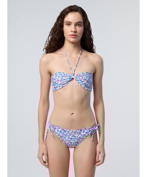 Ein Bikinioberteil, endlose Vielseitigkeit. Dieses wendbare Modell ist auf einer Seite bedruckt und auf der anderen einfarbig. Es besteht aus recycelter Nylon-Mikrofaser und sorgt für ein leichtes Tragegefühl und einen noch geringeren Platzbedarf. Die schicke Bandeau-Silhouette kann flach getragen, in der Mitte gerafft oder im Nacken gebunden werden.