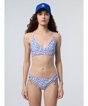 Een omkeerbaar ontwerp voor dubbele stijl. Deze bikinitop is aan de ene kant bedrukt en aan de andere kant effen en gemaakt van gerecycled nylon microvezel voor een licht gevoel en een nog lichtere voetafdruk. De flatterende gekruiste voorkant wordt vastgezet met dunne bandjes achter de nek.