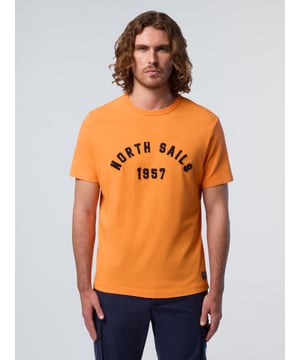 Een casual basic met klassieke charme. Dit T-shirt is gemaakt van dikke jersey van biologisch katoen en voelt zwaarder aan en neemt minder ruimte in. Een label aan de zoom is een eerbetoon aan onze oorsprong als zeilmaker, terwijl een elegante gewassen afwerking het kledingstuk een vintage look geeft.