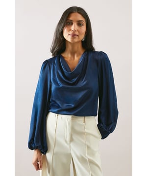 Elegant cowl neckline that drapes beautifully for a sophisticated silhouette
        Statement balloon sleeves with delicate gathered cuffs for a touch of drama
        Lustrous satin finish that catches the light with subtle sheen
        Versatile loose fit that flatters all body types
        Clean-lined design with a smooth back for effortless styling
    
    This Wallis satin blouse combines timeless elegance with contemporary styling. The graceful cowl neckline creates a flattering drape that frames your dcolletage beautifully, whilst the voluminous balloon sleeves add a touch of refined drama to your ensemble. Style as seen with wide-leg trousers and a slim belt for a balanced silhouette that works wonderfully for family gatherings or lunch with friends. The fluid fabric moves gracefully with you, making this piece ideal for daytime events where comfort and style are equally important. Pair with tailored trousers and flats for work, or dress down with your favourite denim and trainers for weekend brunches. This versatile blouse transitions effortlessly from day to evening, making it a wardrobe essential for the modern woman who values both sophistication and comfort.
