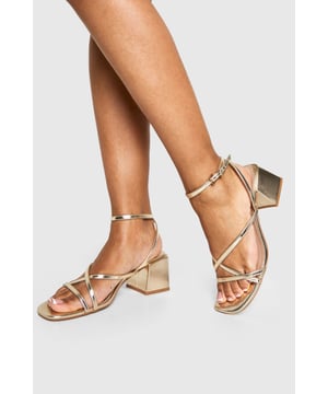 Elegant crossover strap design for a contemporary twist on classic sandals
        Comfortable low block heel measuring between 2.5-4.5cm for all-night wearability
        Metallic finish that catches the light beautifully as you move
        Adjustable ankle strap with secure buckle fastening
        Versatile square toe silhouette that complements various outfits
    
    These striking metallic heels strike the perfect balance between style and comfort, featuring delicate crossover straps that create a flattering effect on the foot. The low block heel provides stability whilst adding just enough height to enhance your silhouette without compromising on comfort during those long nights out. Pair with a sleek mini dress and statement earrings for an evening at the club, or style with tailored trousers and a silky camisole when meeting friends for cocktails. The ankle strap ensures a secure fit as you dance the night away, whilst the metallic finish adds a touch of glamour to any ensemble. These versatile heels transition effortlessly from day to night, making them an essential addition to your footwear collection for any social occasion where you want to make an impression without sacrificing comfort.