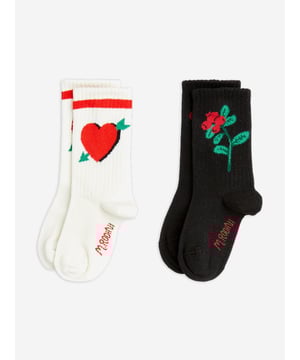 Mini Rodini combine eco-friendly materials with vibrant imaginings to create fun and unforgettable aesthetics. These girls multipack socks showcase two arrowed hearts from different romantic sensibility viewpoints. One pair of socks features the red lovestruck heart with a green arrow on a white base. The other pair feature a gloomy rose on a black background. Ribbed 80 Cotton, 18 Polyamide, 2 Elastane