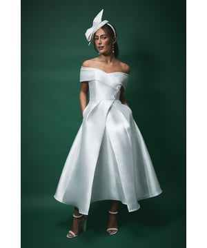 Elegant Bardot neckline with structured fold-over detail
        Sophisticated midi length with dramatic A-line silhouette
        Beautifully tailored waist to create a flattering hourglass shape
        Practical side pockets discreetly integrated into the design
        Structured twill fabric providing exceptional shape retention
    
    Make a striking impression on your special day with this Lisa Tan Bardot Waisted Midi Wedding Dress from Coast. The architectural silhouette features a graceful off-shoulder neckline that frames your dcolletage beautifully, whilst the nipped-in waist and voluminous skirt create a timelessly feminine profile. Perfect for the modern bride seeking a contemporary twist on bridal tradition, this dress works wonderfully for civil ceremonies, registry office weddings or as a second dress for evening celebrations. Style with a statement fascinator as shown for a quintessentially British bridal look, or pair with delicate drop earrings and an elegant updo for refined sophistication. The midi length offers practical versatility, allowing you to showcase a spectacular pair of wedding shoes whilst moving with ease throughout your celebration.