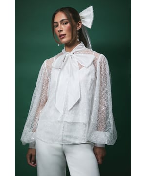 Exquisite sequin-embellished organza blouse with sheer balloon sleeves
        Statement oversized bow detail at the neckline for dramatic bridal flair
        Delicate sheer fabric with subtle sparkle throughout
        Elegant lined bodice ensuring comfort and coverage
        Versatile silhouette that pairs beautifully with trousers or skirts
    
    Make a captivating statement on your special day with this enchanting Lisa Tan bridal blouse from Coast. The dramatic sheer balloon sleeves create an ethereal silhouette whilst the show-stopping bow detail adds a touch of romantic drama. Perfect for the modern bride seeking something uniquely elegant, this blouse offers versatility beyond the wedding day. Style with the matching wide-leg trousers as shown for a contemporary bridal ensemble that breaks from tradition, or pair with a flowing skirt for a more classic interpretation. The delicate sequin embellishment catches the light beautifully as you move, ensuring all eyes remain on you throughout your celebration. This piece transitions wonderfully from ceremony to reception, offering both sophistication and comfort for your most treasured moments.
