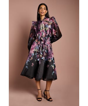 Exquisite organza fabric with a sheer, lightweight finish for elegant movement
        Romantic frill trim detailing cascades down the front for a feminine touch
        Sophisticated tie neck feature allows for customisable styling options
        Structured shoulder design with statement frills creates a dramatic silhouette
        Long balloon sleeves with fitted cuffs offer contemporary elegance
    
    Make a striking impression at your next special occasion with this beautifully crafted organza blouse from Coast. The delicate frills that adorn the front create a captivating cascade effect, whilst the tie neck detail adds versatility to your styling options. The structured shoulders with statement frills create a fashion-forward silhouette that commands attention. Pair with the coordinating midi skirt as shown for a complete occasion ensemble, or style with tailored trousers and statement earrings for a sophisticated look perfect for weddings or race day events. The sheer organza fabric creates a wonderful interplay of light and texture, whilst the regular fit ensures comfort throughout your special event. Complete your look with strappy heels and a clutch bag for an ensemble that reflects Coast's signature occasion-ready elegance.