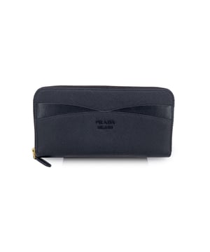 VINTAGE, UVP WIE NEU
Es gibt etwas Unverkennbares und Elegantes an einem klassischen Prada-Portemonnaie – und dieses ist keine Ausnahme. Hergestellt in Italien aus 100 % Kalbsleder mit dem ikonischen Saffiano-Finish erzählt es eine Geschichte von stiller Luxus und zeitlosem Stil. Öffnen Sie es und Sie finden ein durchdacht gestaltetes Innenleben, vollständig mit Stoff ausgekleidet, das mehrere Seitentaschen, Dokumentenfächer und ein Reißverschlussmünzfach bietet – alles an seinem Platz, mit Absicht. Auf der Außenseite bieten vier vordere Kartenfächer schnellen Zugriff, eingerahmt von einem geprägten Prada-Logo, das Prestige flüstert. Mit einem sicheren Rundum-Reißverschlussverschluss ist es sowohl funktional als auch raffiniert – das ist das Art von Stück, das schön altert und mit der Zeit nur besser wird. Zustandsbewertung: A - AUSGEZEICHNETZustandsdetails: Sanft benutzt. Einige normale Gebrauchsspuren auf dem Leder. Bitte prüfen Sie die Fotos sorgfältig und fragen Sie, wenn Sie weitere Details benötigen oder Zweifel haben.Messungen (cm): Höhe: 10,2länge: 19,1Schachtel?: Nein Maße: Länge: 191 mm Höhe: 102 mm