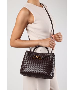 Make a bold statement with this Luna Woven Leather Tote bag with Gold Detail, blending timeless craftsmanship with modern elegance. The rich texture and intricate weave elevate its luxurious appeal, while the gold-tone hardware adds a refined finishing touch. Perfect for evening outings or stylish daywear, it offers both form and function in a sophisticated silhouette. Its structured form ensures it keeps shape while exuding high-end charm. Key Features: • Material: Handwoven faux leather with a premium textured finish • Dimensions: 25cm (L) x 19cm (H) x 10cm (W) • Fastening: Open top with reinforced structured edge • Detail: Decorative gold twist-knot detail and braided handle attachments 