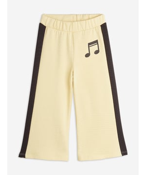 Mini Rodini incorporate environmentally friendly properties into their aesthetics. These girls yellow joggers are woven with wide, brown stripes down the sides. Engineered in a relaxed fit. A large, brown note is embroidered on the front. There is a wide elastic edge which can be tightened with a lace on the inside. 100 Organic Cotton