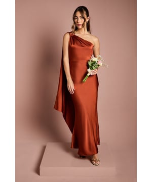 Striking one-shoulder design with elegant gold trim detail
        Luxurious satin fabric creates a smooth, flowing silhouette
        Dramatic draped shoulder panel adds movement and sophistication
        Figure-flattering maxi length with subtle fishtail hem
        Sleek, streamlined cut perfect for formal bridal party coordination
    
    This captivating bridesmaids dress from Coast combines timeless elegance with contemporary design. The asymmetric one-shoulder neckline creates a graceful focal point, whilst the flowing draped panel adds a touch of drama as you move. The satin fabric catches the light beautifully, complemented by the refined gold trim that adds a subtle touch of opulence. The fitted bodice gently flares to a floor-sweeping maxi length, creating a silhouette that flatters every figure. Style with delicate gold jewellery and a simple updo to showcase the distinctive neckline. Complete your bridal party look with strappy heels and a small bouquet that complements the bride's floral arrangements. This sophisticated dress ensures you'll stand confidently beside the bride on her special day, looking effortlessly polished in wedding photographs that will be treasured for years to come.