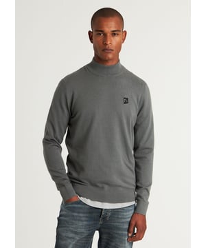 De Ard Mock is een regular fit trui met een mockneck. Voorzien van natuurlijke stretch in de geribde boorden en een CHASIN'-Komma badge op de borst.   Ons model is 188cm lang en draagt maat L.