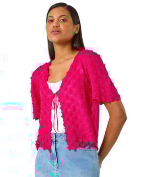 Textured Tie Front Shrug from Roman. Add a touch of texture to your outfit with this stylish shrug. The tie front detail brings a fun and trendy element to this piece. Designed with short sleeves for a light and airy feel, this shrug is perfect for layering over a cami top and jeans for a chic Spring/Summer look.