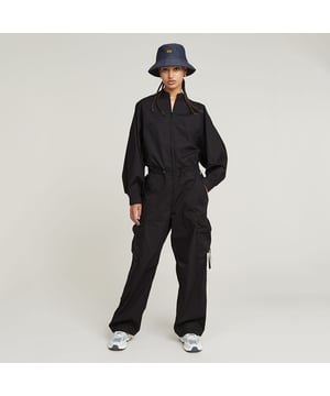 Band collar. Zipper closure. Front and back pockets, 3D thigh pockets, zipper closure. Adjustable waist width, stretchable cord. Adjustable leg width back legs. Zip closure. High waist. Jumpsuit Balloon offers a loose fit. Pull the stretchable cords at the waist to add more shape and volume. The straps at the back allow for a tighter leg. 3D-pockets are added to the thigh and offer a lengthened pull cord. 65% Cotton, 35% Recycled polyester. Rigid. Loose