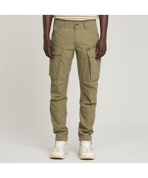 Front zip closure. Cargo-inspired pockets. Back flap button pockets. Adjustable hem. Adjustable leg hem, integrated tape. Button & zip closure. Low waist. Combining utility with a tailored look, the Rovic Zip 3D pant features an integrated tape at the bottom of the leg, ensuring a snug fit around the ankles. 61% Polyester, 39% Elastomultiester. Comfortable stretch. Tapered
