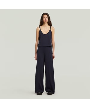 Spaghetti straps. V-neckline. Lightweight fabric. Top attached to pants at the sides only. No closure. Mid waist. The Spaghetti Strap Loose Jumpsuit offers a relaxed fit with spaghetti straps and a V-neck design. 100% Organic Cotton. Comfort stretch. Jersey knit