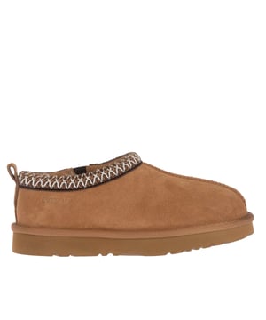 Bovenstuk: Koe Suede Leer. Voering: Schapenvacht. Binnenzool: Schapenvacht. Buitenzool: EVA, Rubber. Stoftechnologie: Duurzaam, waterbestendig. Treklipje. Platte Hak. Snijden: Laag gesneden. Ontwerp: Contrasterende details, Logo. Teenstijl: Rond. Sluiting: Slip-on.
