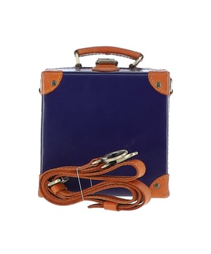 The Ashwood Leather Trinket Box is a limited-edition statement accessory inspired by the golden age of travel, designed to add a romantic flair to your collection. Handcrafted from premium full-grain leather, its structured design features leather-trimmed corners reminiscent of vintage trunk suitcases. The compact, lined interior provides space for a smartphone and a few small essentials, making it both stylish and practical. With a petite top handle and a detachable, adjustable cross-body leather strap, this versatile piece can be carried by hand or worn for hands-free convenience. Dimensions: 18.5cm (L) x 18.5cm (H) x 10cm (W).