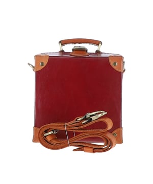 The Ashwood Leather Trinket Box is a limited-edition statement accessory inspired by the golden age of travel, designed to add a romantic flair to your collection. Handcrafted from premium full-grain leather, its structured design features leather-trimmed corners reminiscent of vintage trunk suitcases. The compact, lined interior provides space for a smartphone and a few small essentials, making it both stylish and practical. With a petite top handle and a detachable, adjustable cross-body leather strap, this versatile piece can be carried by hand or worn for hands-free convenience. Dimensions: 18.5cm (L) x 18.5cm (H) x 10cm (W).