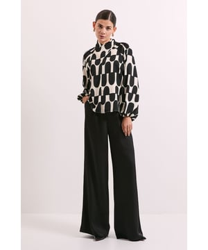 Striking geometric print blouse with eye-catching twist neck detail
        Elegant puff sleeves add volume and contemporary flair
        Sophisticated keyhole back closure for added interest
        Regular fit design ensures comfortable all-day wear
        Versatile crew neckline complements various styling options
    
    Make a statement with this bold printed blouse from Principles. The distinctive twist neck detail and voluminous puff sleeves create a modern silhouette that commands attention. Perfect for elevating your daywear wardrobe, this blouse pairs beautifully with wide-leg trousers as shown for a sophisticated look. Style with your favourite denim and white trainers for weekend brunches, or dress it up with tailored trousers and loafers for casual office days. The graphic pattern works wonderfully with minimal accessories - try simple gold hoop earrings to complement the design without overwhelming it. This versatile piece transitions effortlessly from family gatherings to lunch dates, offering a contemporary twist on casual elegance that will refresh your everyday style rotation.