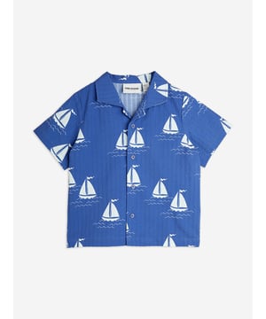 Mini Rodini combine eco-friendly materials with vibrant imaginings to create fun and unforgettable aesthetics. This unisex sailing boats woven blue shirt is woven in refined organic cotton. It has a lapel collar, front button closure, and is embellished with all-over sailboats. Short Sleeves 100 Organic Cotton