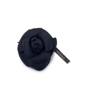 VINTAGE, RRP AS NEW
Chanel Vintage Camellia Flower Pin Brooch - Black Satin  Timelessly feminine and unmistakably Chanel, this Vintage Camellia Flower Pin Brooch captures the Maison's enduring love for the iconic camellia bloom - a signature symbol of elegance and grace. Crafted from luxurious black satin, the layered petals create a soft yet sculptural silhouette that adds depth and dimension to any ensemble.  Measuring approximately 4 inches (10.2 cm) in diameter, this striking brooch is designed to make a subtle yet refined statement. The piece secures with a classic safety pin closure, allowing it to be effortlessly styled on a lapel, hat, scarf, or handbag.  On the reverse, the brooch is finished with the signature 'CHANEL - CC - Made in France' oval ity tab, affirming its heritage and craftsmanship.  A true collector's piece, the Camellia Brooch brings vintage charm and Parisian sophistication to any look - elegant, understated, and eternally chic.  Condition Rating: A - EXCELLENTCondition Details: Gently used. Chanel box included. Please check the photos carefully and ask if you need to know more details or if you have any doubts.  Box?: ?: Yes Measurments:  length: 102 mm strap length: 0 mm handle drop: 0 mm