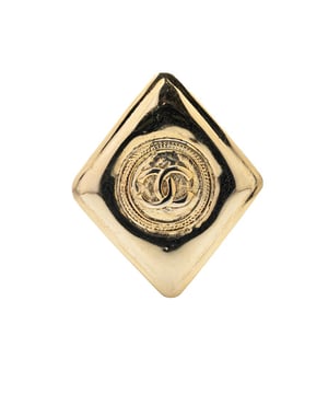 This brooch features a gold-tone metal body and a back pin closure.Brand: Chanel VintageCondition: PrelovedType: Costume BroochRating: B+Main Material: MetalDimensions (LxWxD): 4.7x4x0Comments: Lock Scratched. Exterior Front Scratched.