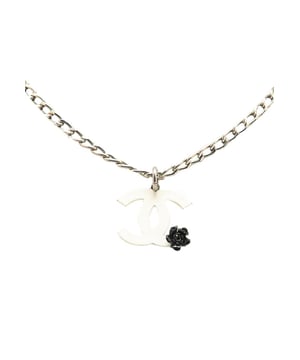 Cadena en tono plateado.
  Charm de camelia de resina.
  Cierre de broche de langosta.
  Disenado para mujeres.