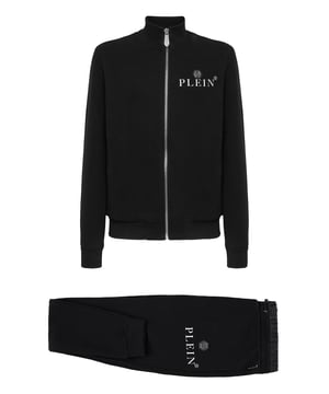 Viva su tiempo libre con el máximo estilo Philipp Plein. Eche un vistazo a los detalles de este chándal jogging.   Suave forro polar de mezcla de algodón.   Inserciones de satén de nailon   Sudadera con cremallera y parche de piel saffiano PP Hexagon cosido en el pecho izquierdo   Dos bolsillos con aberturas   PP Hexagon en una insignia de cuero saffiano cosida en el lado izquierdo de los pantalones   Bolsillos con aberturas   Cintura con cordón de ajuste con tope   Dobladillos de punto elástico