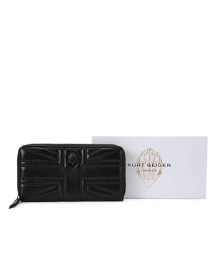 This Kurt Geiger Union Jack Drench Zip Around Purse features a black leather exterior with overstitch quilting creating a Union Jack design. There is a black eagle head with crystals on the front. Dimensions: 10cm (H), 19cm (L), 2cm (D).