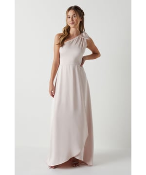 Elegant one shoulder design with a sophisticated bow detail
        Flowing satin fabric that drapes beautifully for a graceful silhouette
        Flattering fitted bodice transitioning into a floor-length skirt
        Subtle wrap-effect hemline creating movement and dimension
        Designed specifically for bridesmaids to complement the bridal party
    
    This enchanting Coast bridesmaids dress combines timeless elegance with contemporary design. The one shoulder neckline with its delicate bow detail creates a refined asymmetric look that photographs beautifully from every angle. The fitted bodice gently hugs your figure before flowing into a graceful floor-length skirt with a subtle wrap effect that adds movement as you walk down the aisle. Perfect for the bridal party, this dress can be styled with delicate jewellery and an elegant updo to mirror the model's sophisticated half-up hairstyle. Complete your bridesmaids look with strappy heels and a small clutch that coordinates with the wedding colour scheme. The satin fabric catches the light beautifully, ensuring you'll shine in your supporting role on the special day whilst maintaining the perfect balance of sophistication and grace.