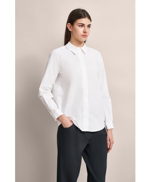 Ervaar het comfort en de elegantie van de bugatti overhemdblouse van een elastische katoen-elastaanmix. Deze blouse wordt gekenmerkt door een blinde knoopsluiting en eenvoudige manchetten met 1 knoop. Dankzij de split aan de zijkant biedt het extra bewegingsvrijheid. Een must-have voor elke garderobe - perfect voor zakelijk of casual gebruik.