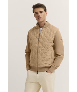 Die bugatti Strickjacke vereint Eleganz und Funktionalität. Der vordere Teil ist mit einer charakteristischen Rautensteppung versehen, während Ärmel und Rückenteil aus hochwertigem Strick gefertigt sind. Dezente Details wie das Flaglabel, praktische Leistentaschen sowie Rippenbündchen an Ärmeln und Saum machen diese Jacke zu einem perfekten Begleiter für die Übergangszeit.