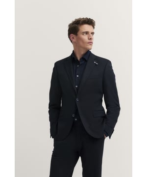 Mit dem bugatti Sakko erlebst Du ultimativen Komfort dank der integrierten Stretchfunktion und des hochwertigen Jersey-Stoffs. Der moderne Schnitt sorgt für eine zeitgemäße Silhouette, während Reverskragen, Pattentaschen und eine elegante Vollfütterung dem Sakko eine edle Note verleihen. Perfekt für den stilbewussten Mann.