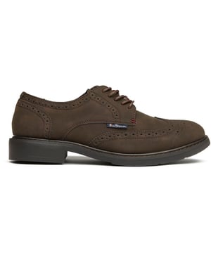El Ben Sherman Patrick aporta la sofisticación clásica del brogue al armario del caballero moderno. La parte superior sintética en marrón intenso luce los tradicionales detalles perforados, mientras que los cordones encerados aportan ese toque final esencial. Fabricados con una suela de goma resistente para una comodidad duradera y la inconfundible herencia de Ben Sherman, estos brogues combinan a la perfección con ocasiones formales y un estilo elegante e informal.