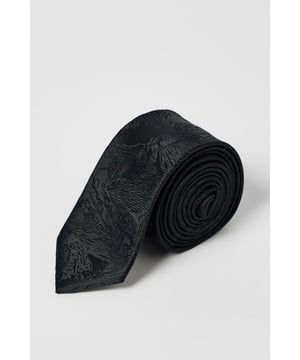 Sophisticated floral textured design adds subtle depth and character
        Slim profile creates a modern, streamlined appearance
        Standard length perfect for traditional knotting techniques
        Versatile black tone pairs effortlessly with any formal or smart-casual ensemble
        Branded Burton label ensures authentic quality and craftsmanship
    
    This textured tie combines classic style with contemporary flair, featuring an understated floral pattern that creates visual interest without overwhelming your look. Perfect for the gentleman who appreciates refined details, it pairs brilliantly with a crisp white shirt and charcoal suit for important meetings or special occasions. The versatile design transitions seamlessly from daytime office wear to evening gatherings at your local. Style with a simple knot for casual family events or opt for a more elaborate Windsor knot when attending formal functions. Machine washable at 30 degrees, this tie offers practicality alongside style - ideal for the man who values both tradition and convenience. A wardrobe essential that brings subtle sophistication to any outfit without trying too hard.