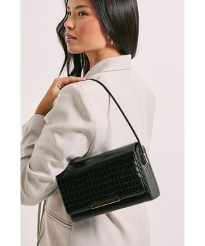 Structured shoulder bag with eye-catching croc print texture
        Sleek metal bar detail adorning the front flap
        Versatile top handle for easy carrying
        Compact size perfect for essentials
        Secure flap closure to keep belongings safe
    
    Make a statement with this chic croc print structured shoulder bag from Dorothy Perkins. Its compact yet practical design is ideal for the fashion-forward woman who values both style and functionality. The textured exterior adds a touch of sophistication, while the sleek metal bar detail on the front flap gives it a modern edge. Perfect for a night out with friends or a trendy brunch date, this bag effortlessly transitions from day to evening wear. Pair it with a sleek midi dress and strappy heels for a polished look, or dress it down with tailored trousers and a blouse for a more casual yet refined ensemble. The versatile design allows you to carry it by the top handle or wear it over the shoulder, adapting to your needs throughout the day. This bag is a must-have accessory for the woman who wants to add a dash of urban chic to her wardrobe without compromising on practicality.