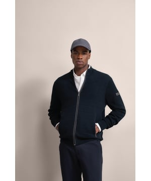 Entdecke den eleganten Komfort der bugatti Strickjacke! Dieses Modell aus einem luxuriösen Baumwoll-Kaschmir-Mix besticht durch seinen modernen Stehkragen und die raffinierten 3-D-Teilungslinien. Die Details in Flanell am Reißverschluss und an den Taschen fügen einen edlen Touch hinzu, ergänzt durch eine stilvolle Metallplakette am Ärmel. Mit praktischen Reißverschlusstaschen und einer bequemen Passform - ein unverzichtbares Stück für deine Garderobe!