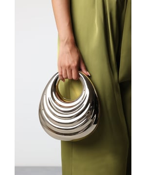 Make a bold style statement with the Lagoon Chrome Effect Sculpted Oval Handle Clutch, a striking accessory designed to turn heads. Featuring a sleek, high-shine chrome finish and a distinctive sculpted oval handle, this clutch blends contemporary design with timeless elegance. The open-top design allows easy access to your essentials, while the structured silhouette ensures it keeps its unique shape. Perfect for parties, weddings, and special occasions where standout style is a must. Key Features: • Material: Chrome-effect high-shine finish with smooth lining • Dimensions: 26cm (H) x 22cm (L) x 10cm (W) • Fastening: Open-top design for easy access • Detail: Unique sculpted oval handle for a modern, eye-catching look