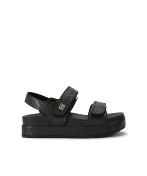 This Raymond sandal is crafted from a black woven raffia. There are two velcro fastened straps across the foot and a slingback strap at the ankle.