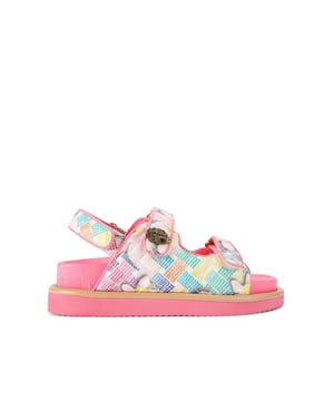 The Kurt Geiger Orson sandal features a canvas fabric upper with watercolour style floral print. The straps are velcro with an antiqued brass eagle head emblem sat on top.