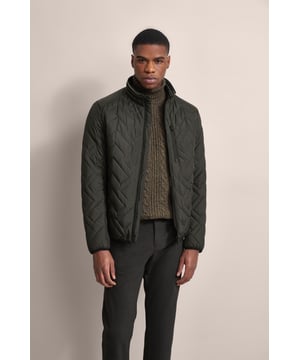 Ervaar het comfort en de stijl van de bugatti blouson in een moderne gewatteerde look. Deze lichtgewicht nylon blouson is ideaal voor op reis en biedt optimaal comfort en warmte met zijn opstaande kraag, gebreide manchetten aan de mouwen en romp en gevoerde voorkant - zonder gebruik van echt dons. Er is ook een praktische zak met rits op de borst!
