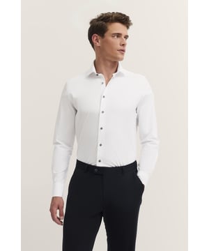 Das Jerseyhemd von bugatti überzeugt mit seinem weichen Jersey-Material und einem Stretchanteil, der Dir optimalen Tragekomfort bietet. Der klassische Kentkragen und der cleane Look machen dieses Hemd vielseitig kombinierbar, während die dezente bugatti Flag in der Seitennaht einen dezenten Akzent setzt..