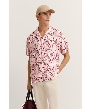 Het bugatti resort shirt in ¥regular fit' biedt je een perfecte mix van comfort en stijl met zijn lichte viscosemix en losse reverskraag. De rechte zoom en subtiele print geven het overhemd een relaxte, moderne look, terwijl de bugatti-vlag op de zijnaad een subtiel accent toevoegt.