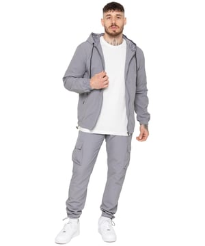 Stay ready for any weather with the Enzo Milano Men’s Windbreaker Jacket, designed with a lightweight, regular fit. Made from durable, water-repellent tech fabric, it features a full zip, adjustable drawstring hood, elasticated cuffs, and hem for comfort and protection. With two concealed zip pockets, an inner pocket, and the signature Enzo Milano rubber badge, it’s both functional and stylish. Pair it with the Enzo Milano Men’s Cargo Pants, crafted from lightweight poly fabric in a straight-leg, regular fit. They feature an elasticated waistband with drawstring, adjustable hems, and secure Velcro cargo pockets plus a back welt pocket. Ideal for everyday wear, travel, or outdoor use.