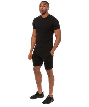 Mantente elegante y cómodo con este conjunto de Enzo. La camiseta entallada, hecha de tejido elástico extra, cuenta con cuello redondo, mangas cortas y logotipo bordado. Los pantalones cortos de forro polar incluyen cintura elástica con cordón, dos bolsillos y el logotipo bordado a juego. Perfecto para entrenamientos, fines de semana o uso casual.