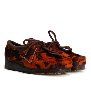 Premium mocassinestijl schoen met een bovenwerk van koeienvacht, met de hand gestikte neusnaad. Afgewerkt met een natuurlijke kiezelkreetzool in een rijke koffiekleur voor een klassieke stijl en comfort.