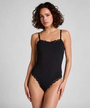 Voel en zie er elegant uit in deze prachtige gladmakende body. Met kanten details aan de halslijn en onderkant, voegt het een vleugje allure toe. Het heeft verstelbare bandjes, een kruissluiting en een extra laag bij de borst voor extra bedekking.